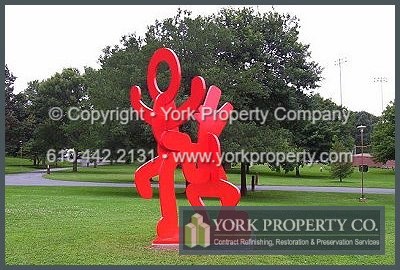 The Solution: The Keith Haring Foundation of New York City entrusted us to paint and restore the painted steel sculpture removing the rust, graffiti, vandalism and scratches. We had to grind off the graffiti, rust and scratches, fill the voids and sand the entire statue smooth. The steel was primed and painted Imron red with our exterior painted steel refinishing system. The painted steel statue now stands restored, refurbished and reconditioned.