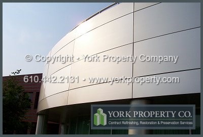 Professional company washing dirty exterior silver colored anodized aluminum clad paneling.
