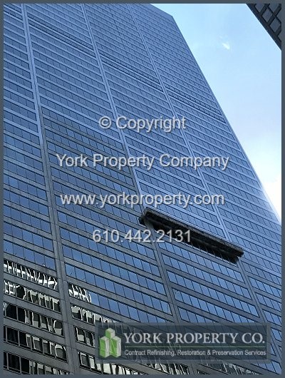 Professional company cleaning dirty stainless steel building facades.