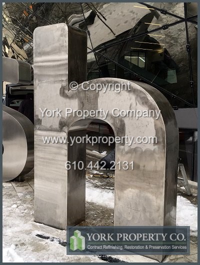 On-site exterior stainless steel sign refinishing.