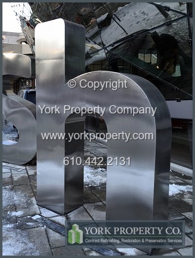 On-site exterior stainless steel sign refinishing.