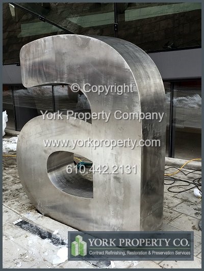 On-site exterior stainless steel sign refinishing.