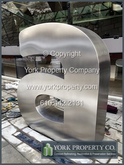 On-site exterior stainless steel sign refinishing.
