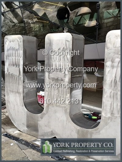 On-site exterior stainless steel sign refinishing.