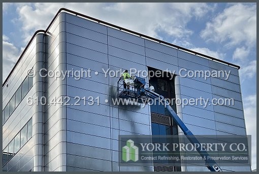 Repairing damaged stainless steel building facade panels.