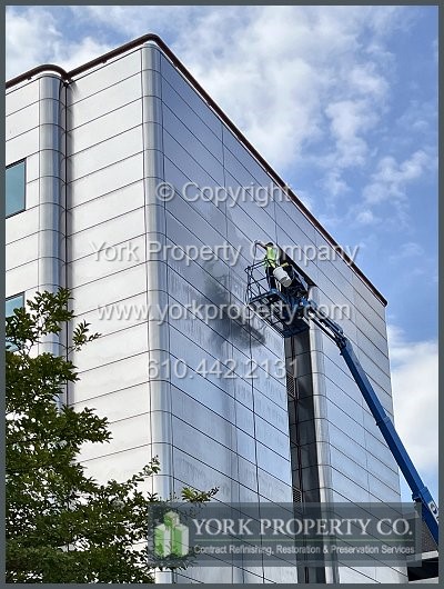 Scratched stainless steel building facade refinishing contractor.