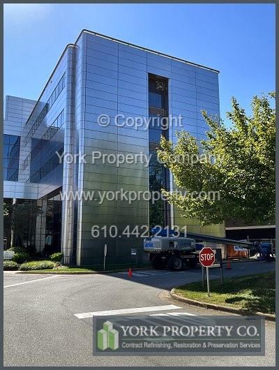 Cleaning rust off of exterior stainless steel building facade panels.