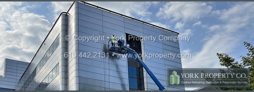 Repairing scratches on damaged exterior stainless steel clad paneling.