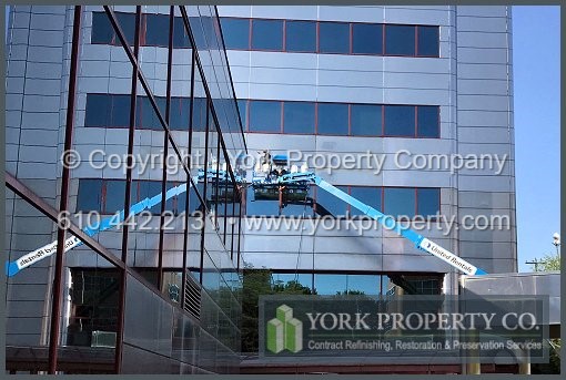 Cleaning dirty stainless steel building facade panels.