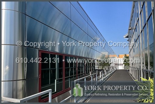 Professional company cleaning weathered stainless steel building facade panels near me locally.