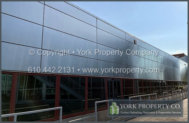 Repairing damaged stainless steel panels in an exterior building facade.