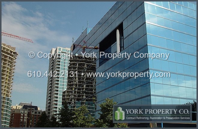 Painting faded painted aluminum curtain wall window mullions.