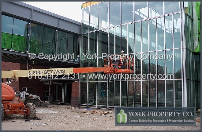Exterior clear anodized aluminum restoration cleaning and concrete, mortar and cement overspray removal.