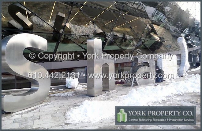 On-site exterior stainless steel sign refinishing.