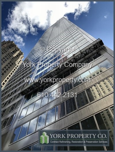 Washing old and oxidized stainless steel facade panels. Oxidized stainless steel building facade restoration. Removing dry peeling paint from bronze anodized aluminum window frame sills.