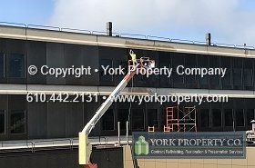 Cleaning dirty exterior commercial high-rise stainless steel curtain wall building clad panels. Stainless steel scratch removal.