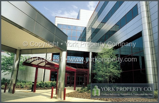 Refurbishing and repairing damaged, stained and rusting exterior metal building facade metal panels.