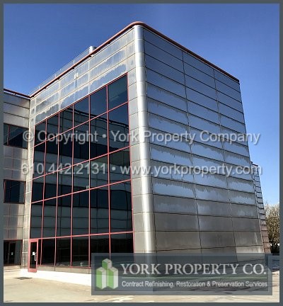 Company cleaning dirty stainless steel spandrel panels.