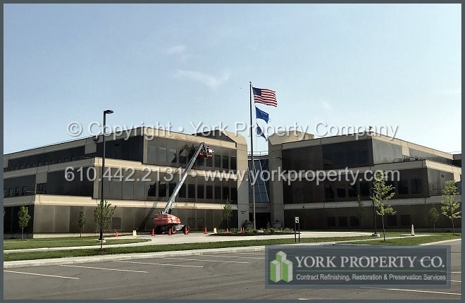 Washing hard water pollution stains off of the exterior of dark bronze anodized aluminum clad panels.